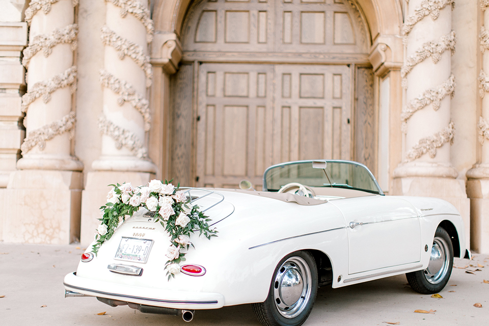  black and white classic wedding with the bride in a modern ballgown with billow sleeves and the groom in a black tuxedo – vintage car
