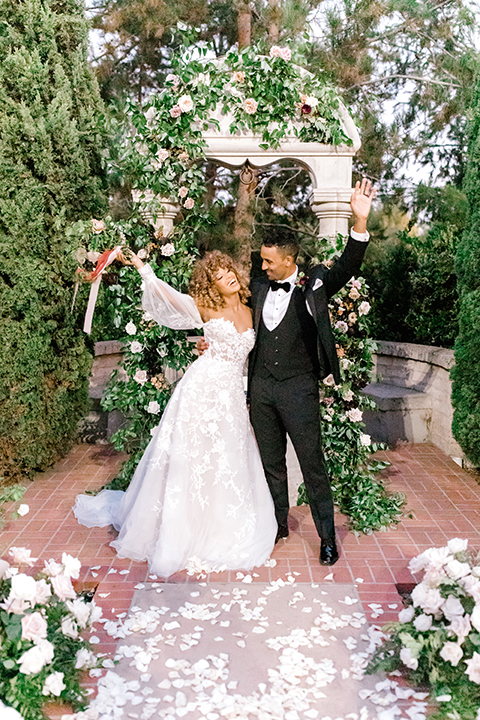  black and white classic wedding with the bride in a modern ballgown with billow sleeves and the groom in a black tuxedo – ceremony 