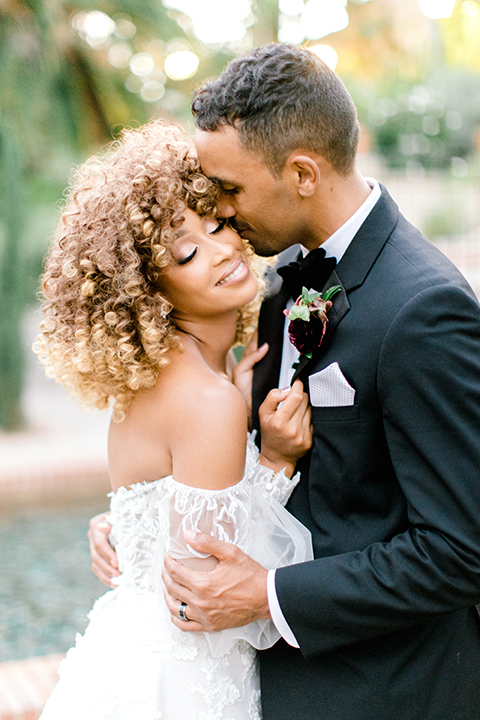  black and white classic wedding with the bride in a modern ballgown with billow sleeves and the groom in a black tuxedo – couple embracing and dancing 