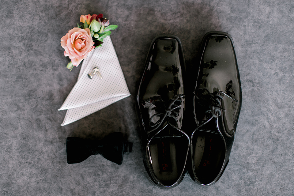  black and white classic wedding with the bride in a modern ballgown with billow sleeves and the groom in a black tuxedo – grooms accessories