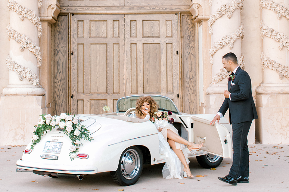  black and white classic wedding with the bride in a modern ballgown with billow sleeves and the groom in a black tuxedo – couple in car
