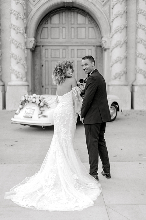  black and white classic wedding with the bride in a modern ballgown with billow sleeves and the groom in a black tuxedo – couple walking across the street 