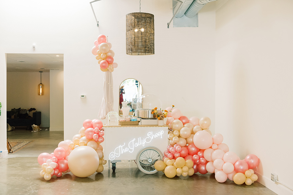  colorful modern wedding with the bride in a fitted gown and the groom in an ivory coat and pink pants – cotton candy machine