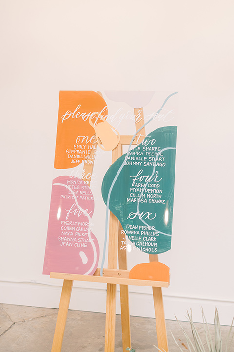  colorful modern wedding with the bride in a fitted gown and the groom in an ivory coat and pink pants – wedding signage