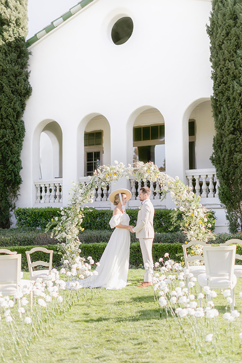  elevated cottagecore wedding design with the bride in a long sleeve ball gown and the groom in a tan suit - couple at ceremony 