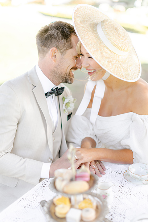  elevated cottagecore wedding design with the bride in a long sleeve ball gown and the groom in a tan suit - couple at the table 