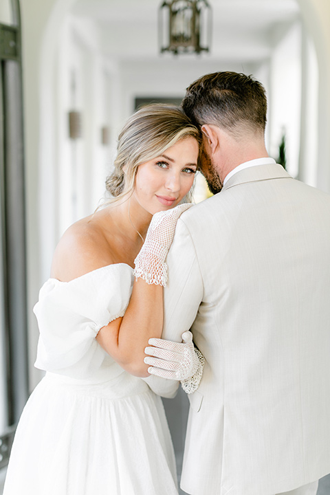  English garden romantic wedding with the bride in an off-the-shoulder gown and the groom in a tan suit – couple embracing 