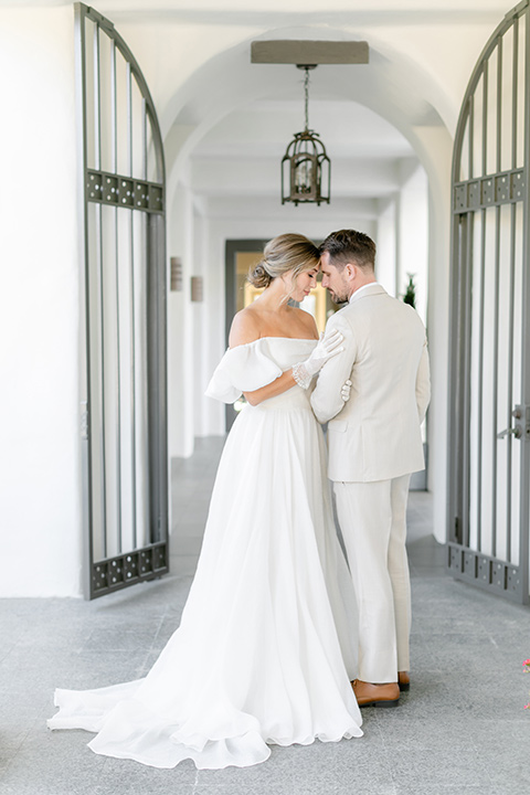  elevated cottagecore wedding design with the bride in a long sleeve ball gown and the groom in a tan suit - couple embracing 