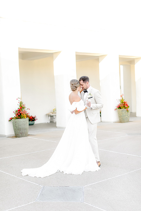  elevated cottagecore wedding design with the bride in a long sleeve ball gown and the groom in a tan suit - couple dancing 