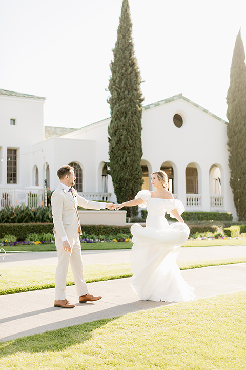  English garden romantic wedding with the bride in an off-the-shoulder gown and the groom in a tan suit – dancing on the grass 