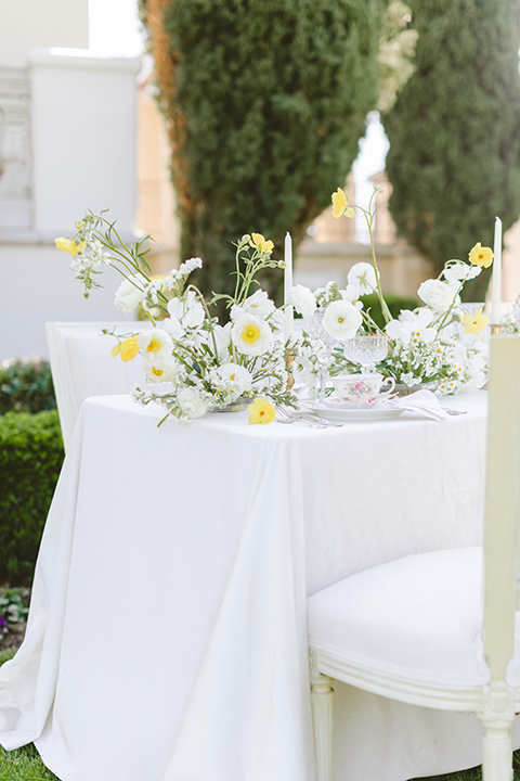  elevated cottagecore wedding design with the bride in a long sleeve ball gown and the groom in a tan suit - table decor 