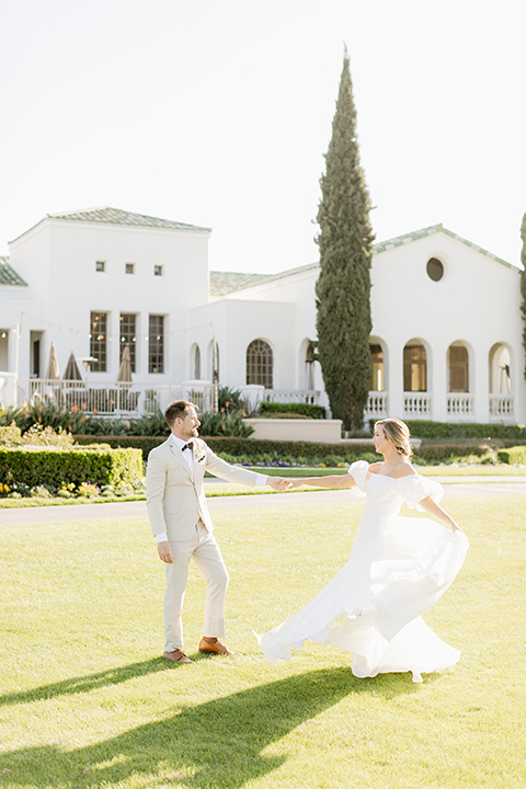  elevated cottagecore wedding design with the bride in a long sleeve ball gown and the groom in a tan suit - dancing on the grass 