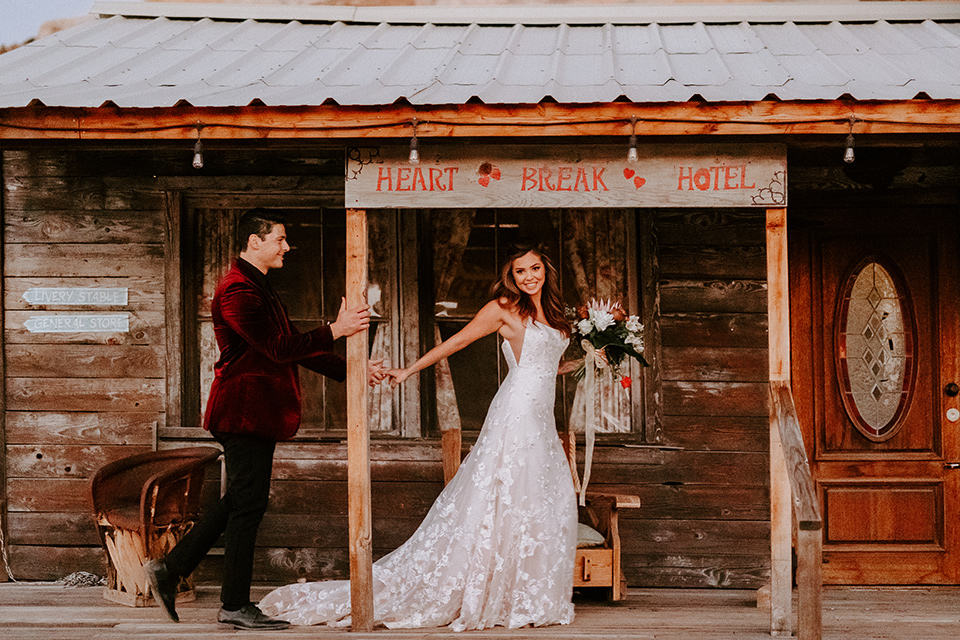  boho burgundy and beige wedding in the dessert – couple outside the venue 
