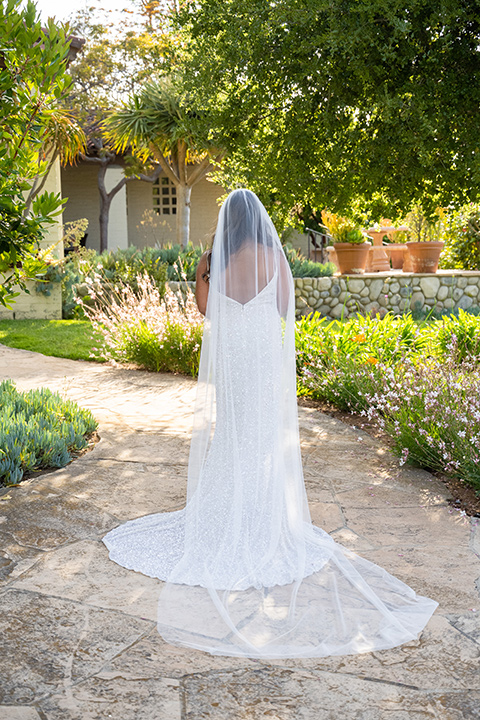  a modern black and white wedding with crystal details -the bride in a lace formfitting gown and the groom in a white + black tuxedo – bride in her gown