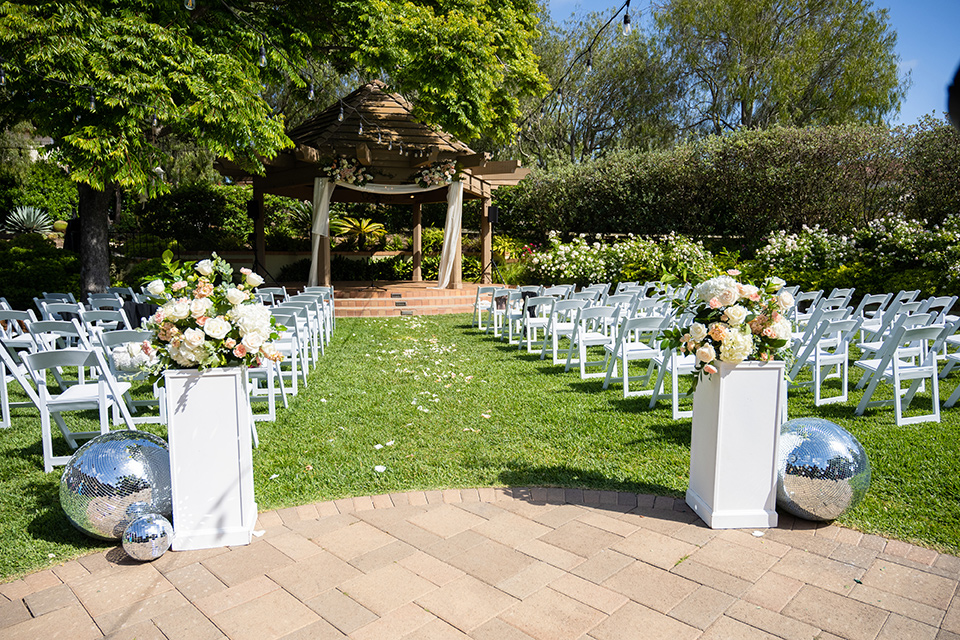  a modern black and white wedding with crystal details -the bride in a lace formfitting gown and the groom in a white + black tuxedo –ceremony