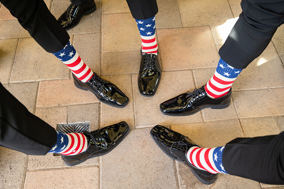  a modern black and white wedding with crystal details -the bride in a lace formfitting gown and the groom in a white + black tuxedo – groomsmen socks