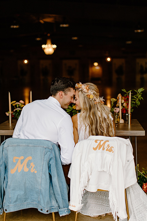  retro boho wedding with amber and brown color scheme – couple sitting at sweetheart table with jackets