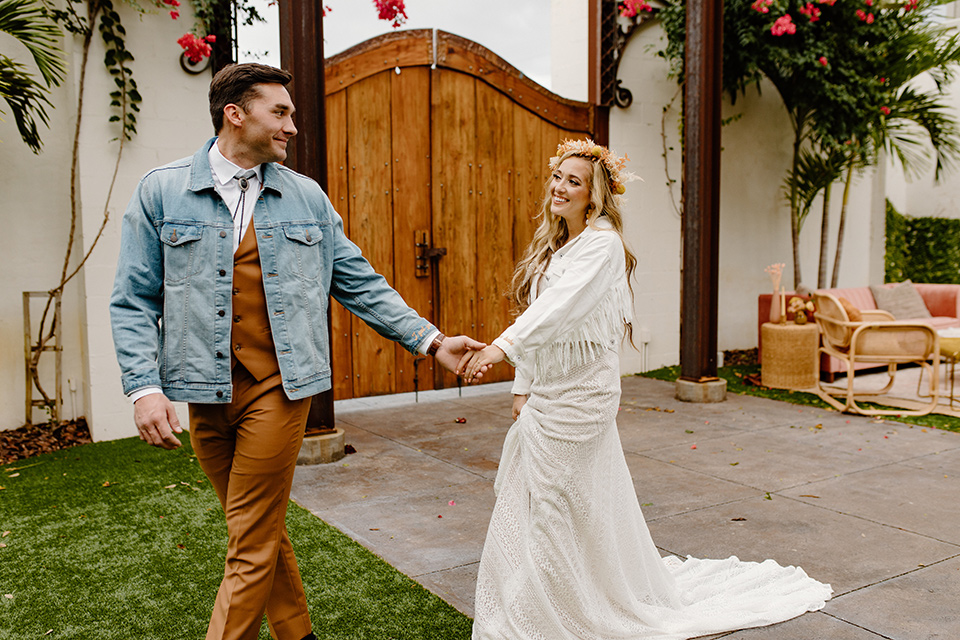  retro boho wedding with amber and brown color scheme – couple holding hands and walking