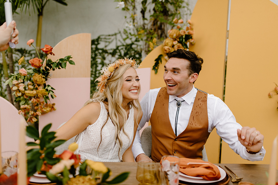  retro boho wedding with amber and brown color scheme – couple laughing at the table