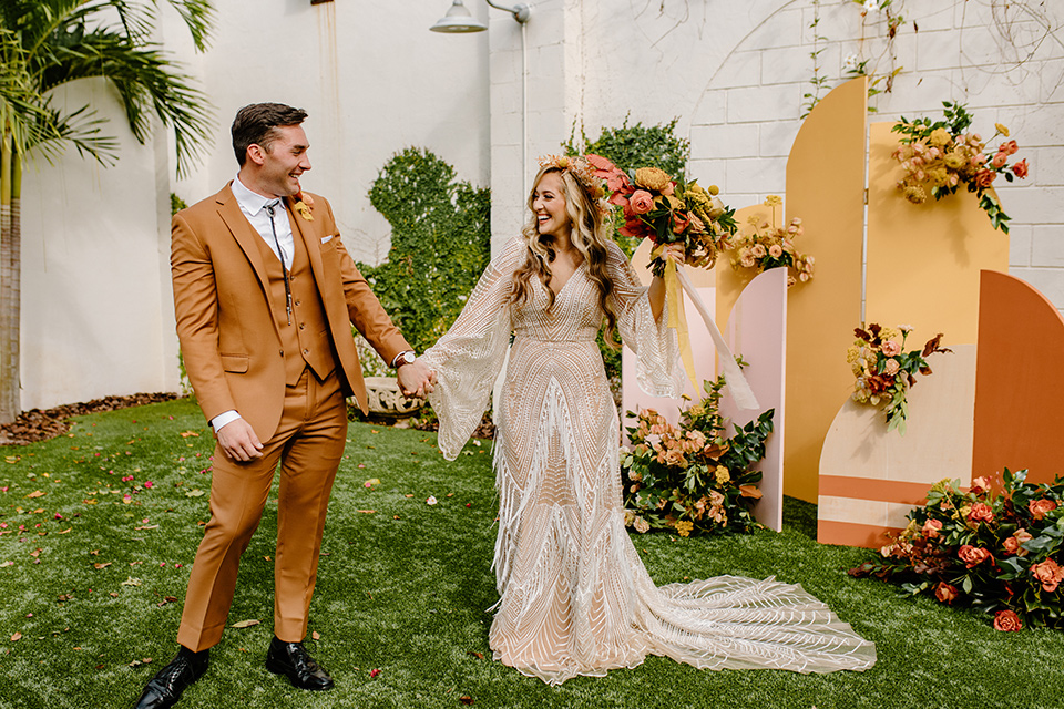  retro boho wedding with amber and brown color scheme – couple holding hands