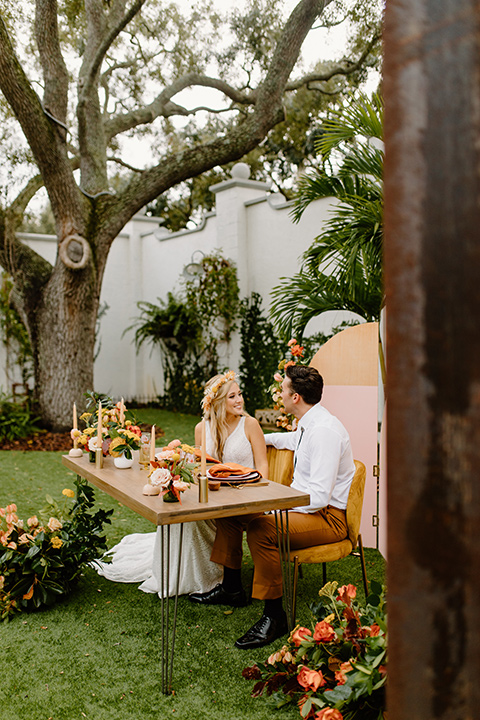  retro boho wedding with amber and brown color scheme – couple sitting at the table 