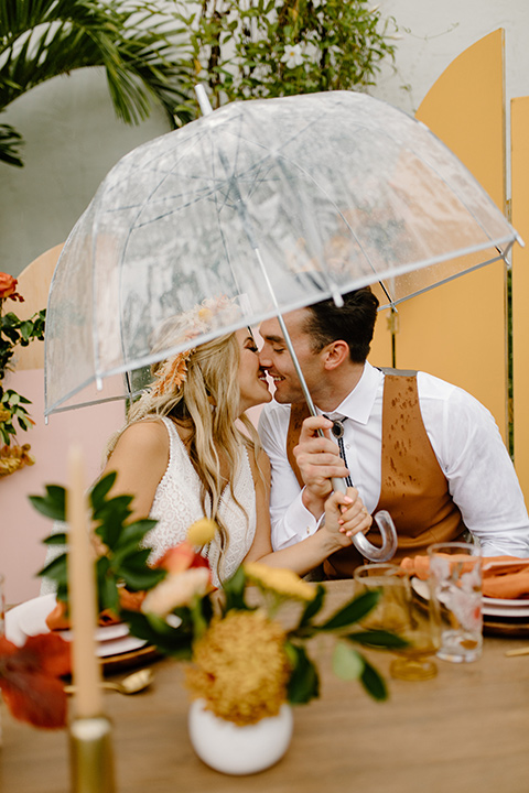  retro boho wedding with amber and brown color scheme – couple with umbrella 
