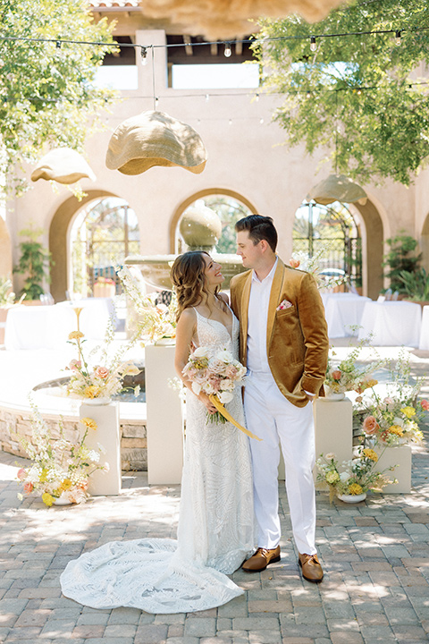  a colorful wedding inspired by the Amalfi Coast with the groom in different wedding day looks – couple embracing, groom in gold velvet tuxedo 