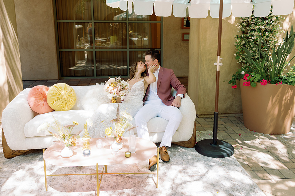 a colorful wedding inspired by the Amalfi Coast with the groom in different wedding day looks – couple on couch 