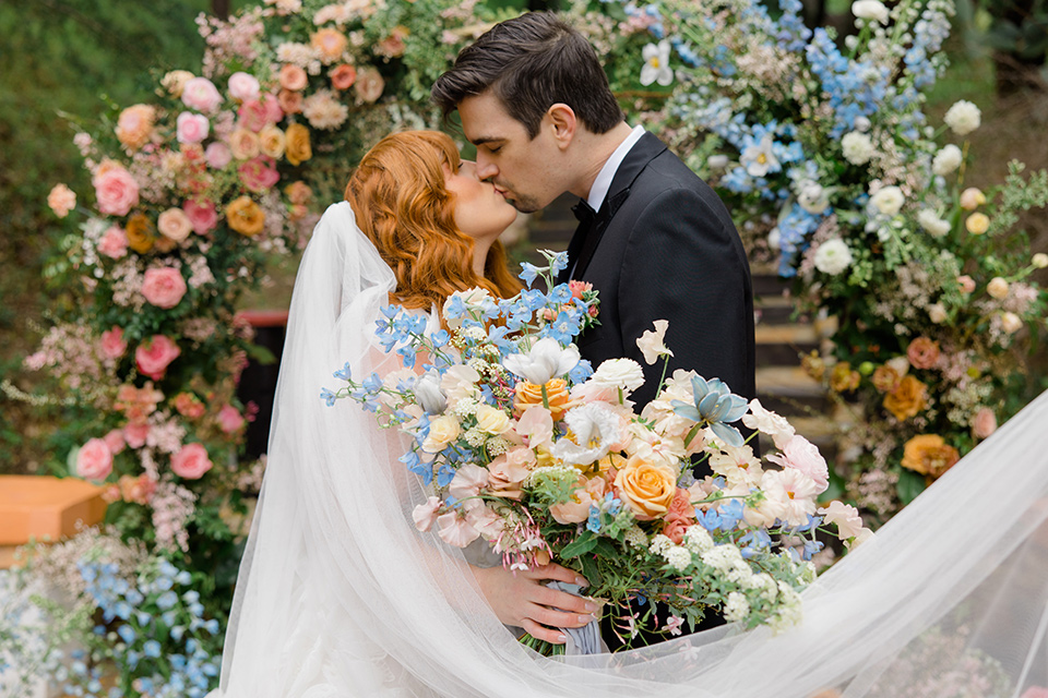  a colorful wedding with black tie style - couple kissing with veil 