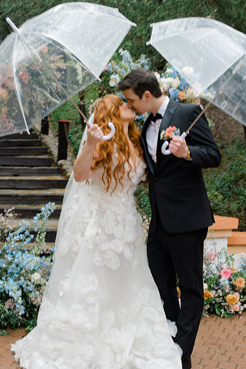  a colorful wedding with black tie style – couple walking with umbrellas 