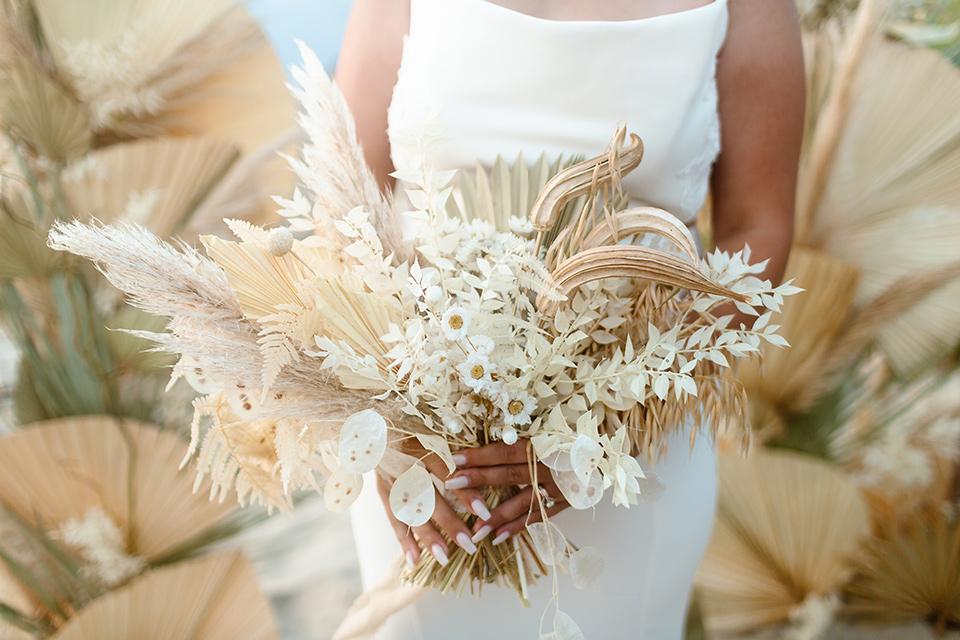  a neutral beachy elopement with the groom in a tan suit and the bride in a white lace dress – florals and bridal bouquet 