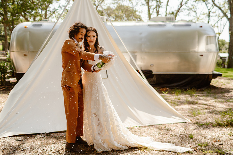  a boho caramel wedding inspo with an airstream and pampas grass – couple with champagne 