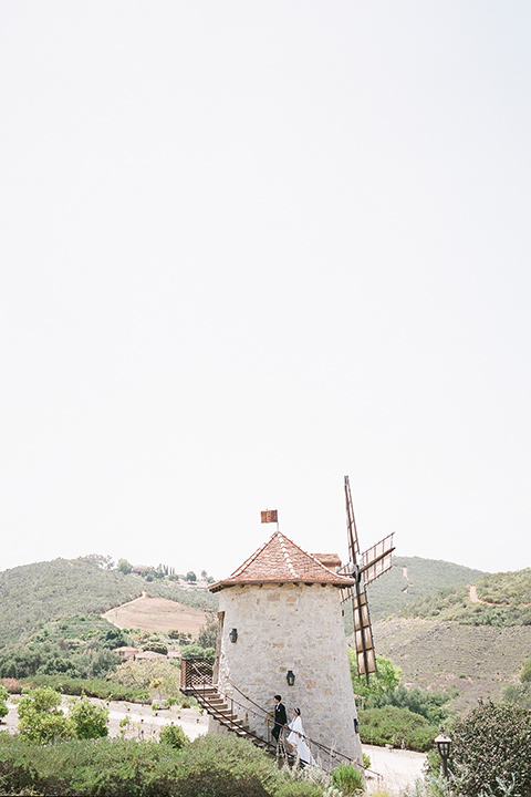  a European romantic wedding with an old world ethereal vibe – couple walking on the windmill 