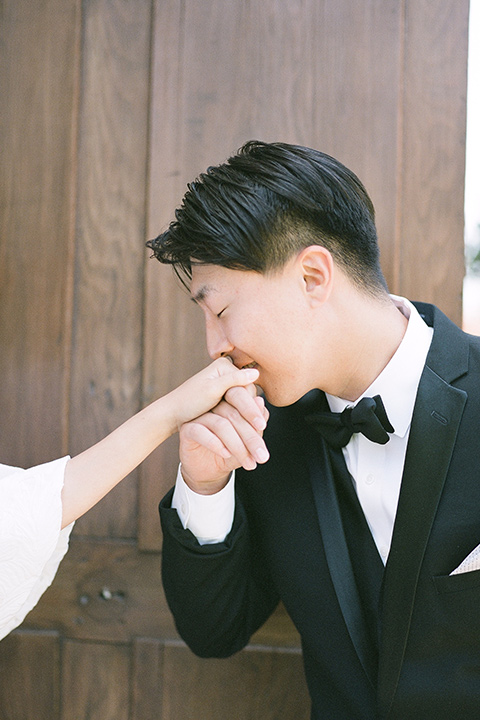  a European romantic wedding with an old world ethereal vibe – groom kissing the brides hand 