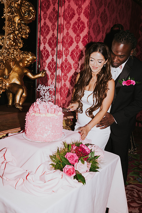  a grand pink and rose las vegas style wedding with bold trendy details – cutting the cake 