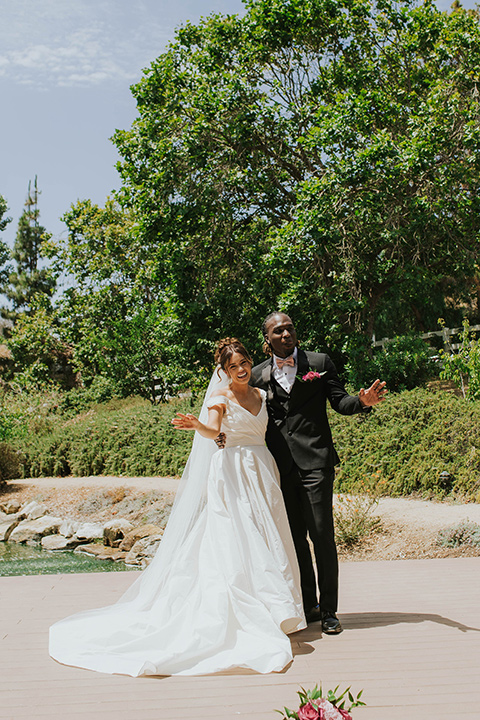  a grand pink and rose las vegas style wedding with bold trendy details – couple smiling and walking 