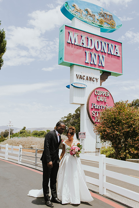  a grand pink and rose las vegas style wedding with bold trendy details – couple in front of the venue 