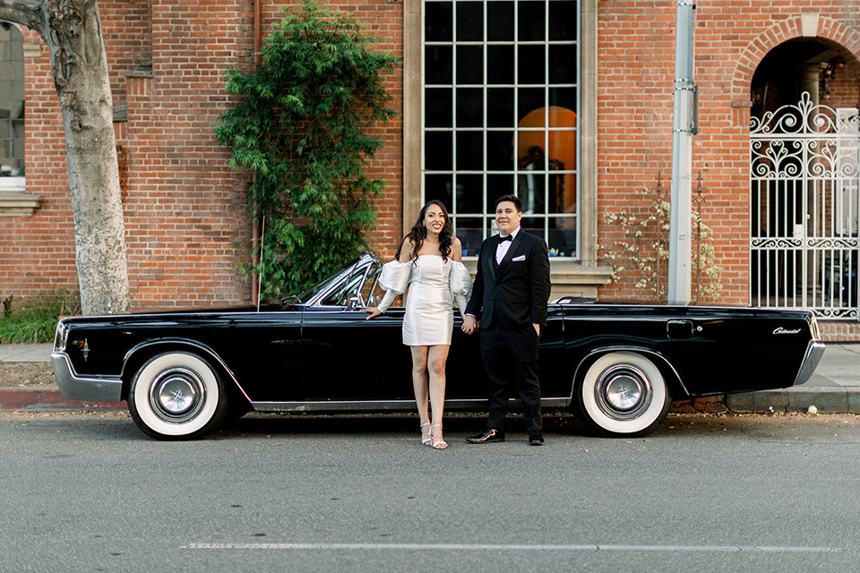  a classic blush and black wedding in a church - couple with the vintage car 