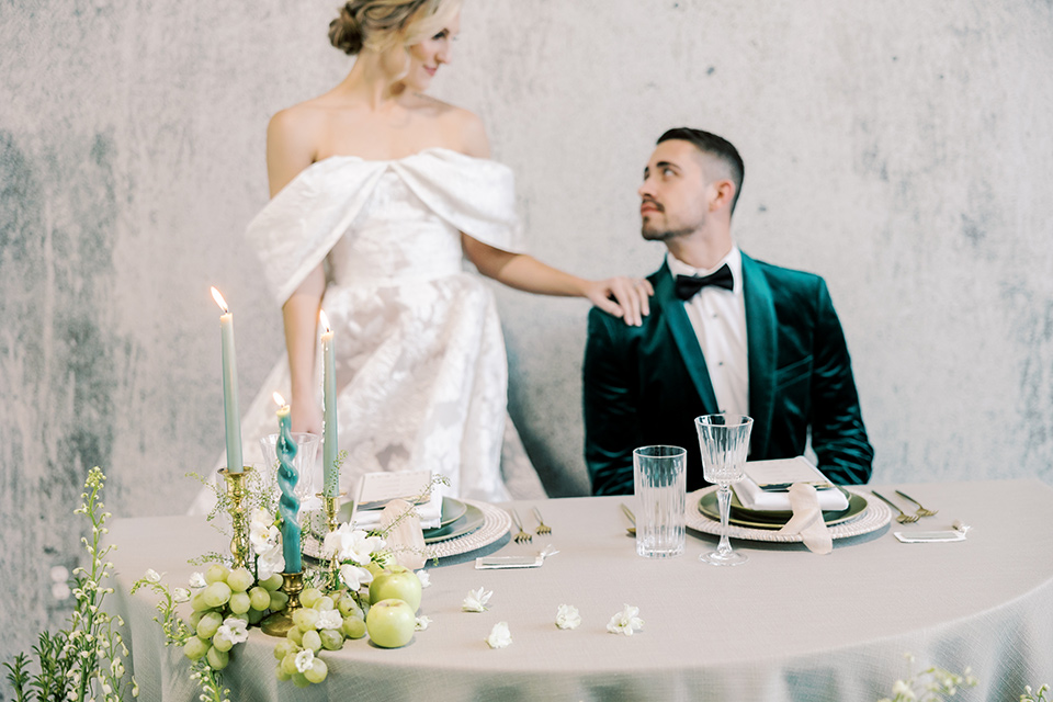  an old money luxury wedding vibe with green and black tones – couple at sweetheart table 