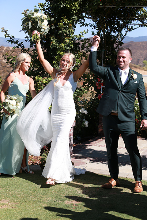  a green toned wedding with an outdoor venue - cheering at the ceremony 
