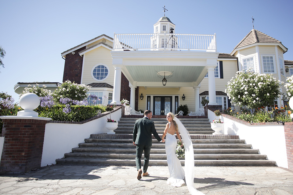  a green toned wedding with an outdoor venue - couple walking up the stairs 