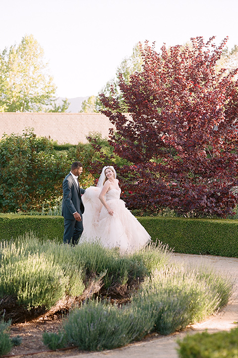  a dreamy garden wedding at Kestrel Park with the groom in a Navy Shawl tuxedo - couple walking 