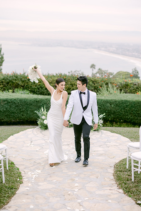  a monochromatic modern wedding at La Venta Inn with the bride in a sleek gown and the groom in a white tuxedo - couple at ceremony 