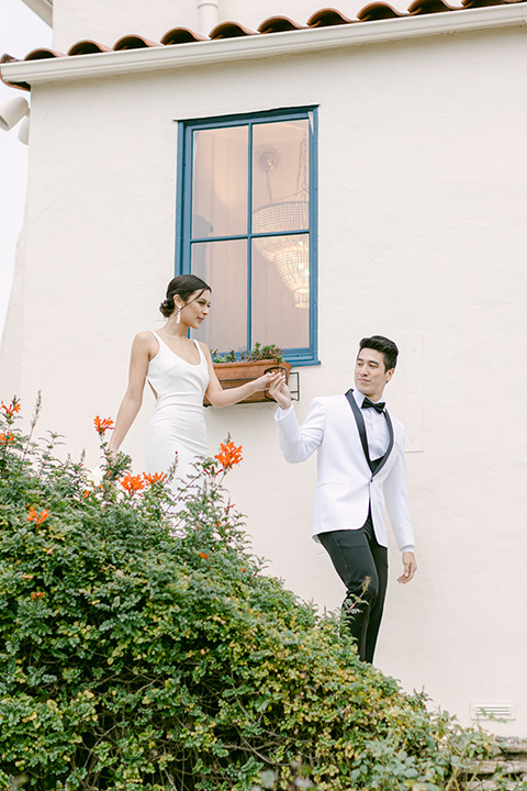  a monochromatic modern wedding at La Venta Inn with the bride in a sleek gown and the groom in a white tuxedo - couple walking around the venue 