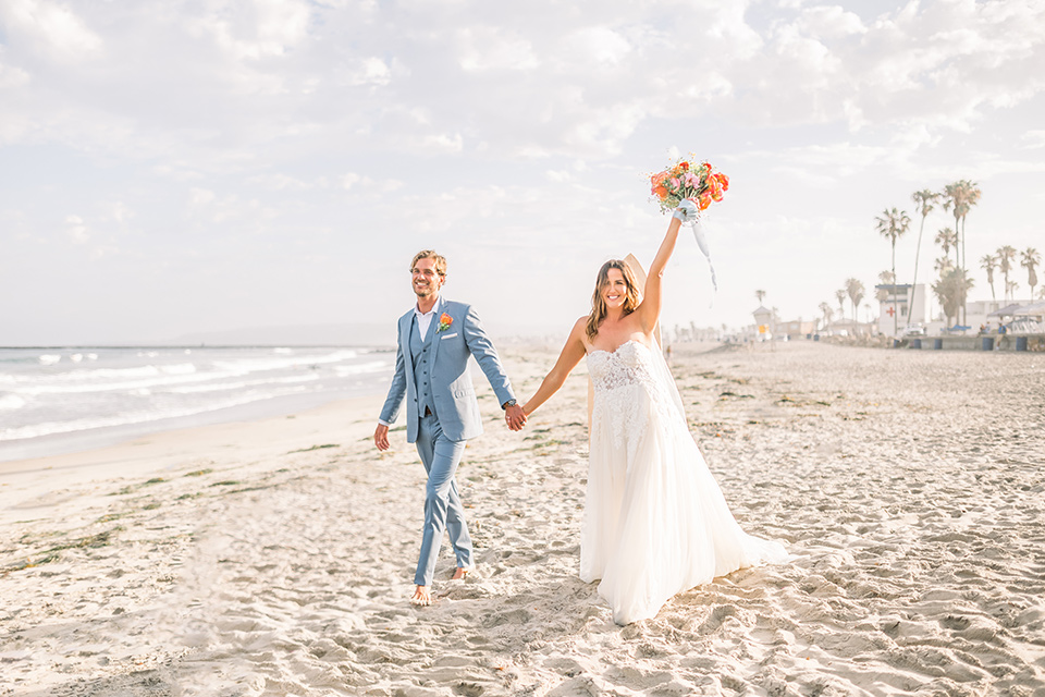  couple eloping on the beach with bright vibrant colors - couple cheering 