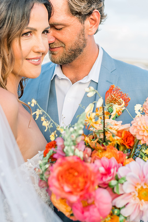  couple eloping on the beach with bright vibrant colors - couple with flowers 