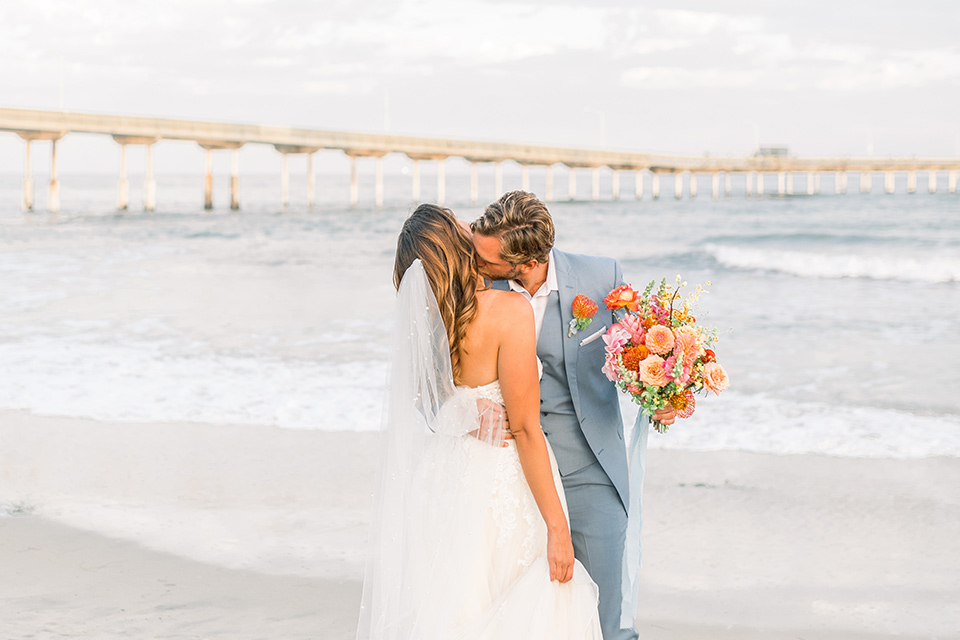  couple eloping on the beach with bright vibrant colors - walking away 