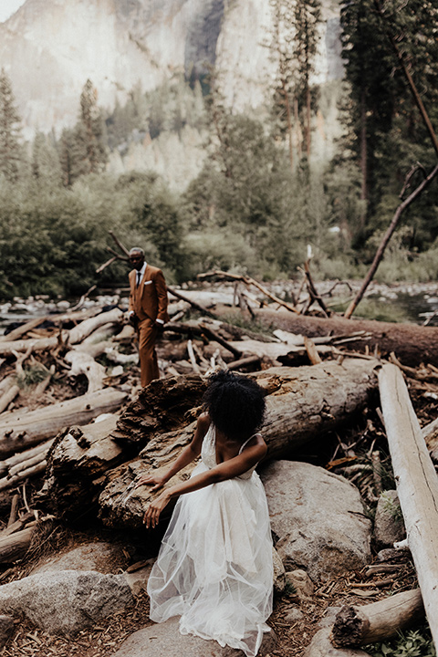  a woodland shoot in the sequoias with the groom in a caramel suit and the bride in a boho gown – couple by the lake 