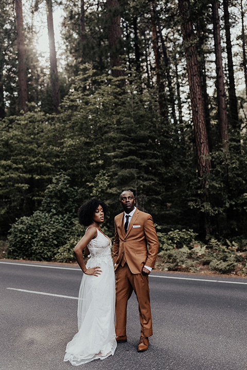  a woodland shoot in the sequoias with the groom in a caramel suit and the bride in a boho gown – couple in the street 
