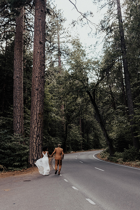  a woodland shoot in the sequoias with the groom in a caramel suit and the bride in a boho gown – couple in the street 
